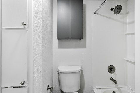 A white toilet in a bathroom with a white door and a white wall.