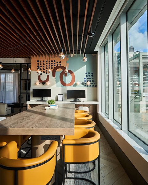 A modern dining area with a wooden table and yellow chairs.