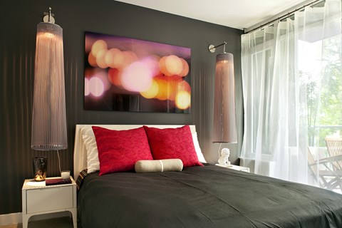 A bedroom with a large bed and a painting on the wall.