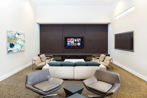 A living room with a couch, chairs, and a television.