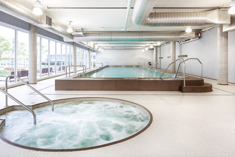 A large indoor swimming pool with a hot tub.