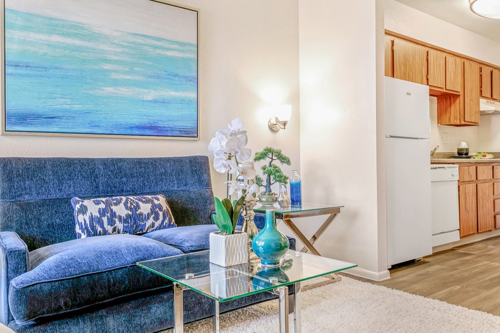a living room with a blue couch and a glass table