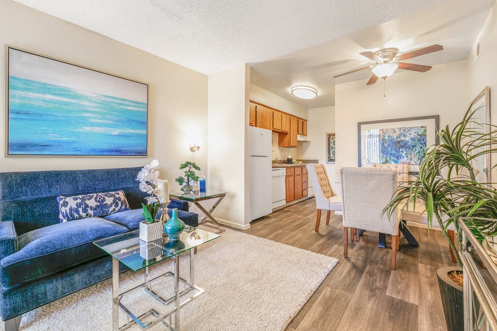 a living room with a blue couch and a ceiling fan