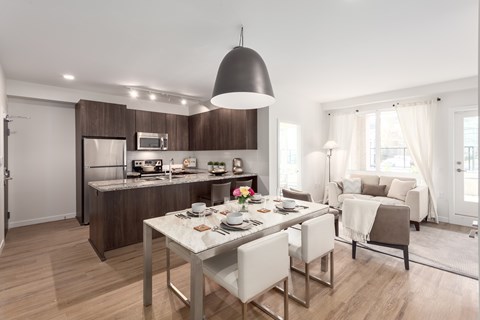 A modern kitchen with a dining table set for two.