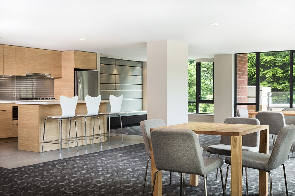 A modern dining area with a wooden table and grey chairs.