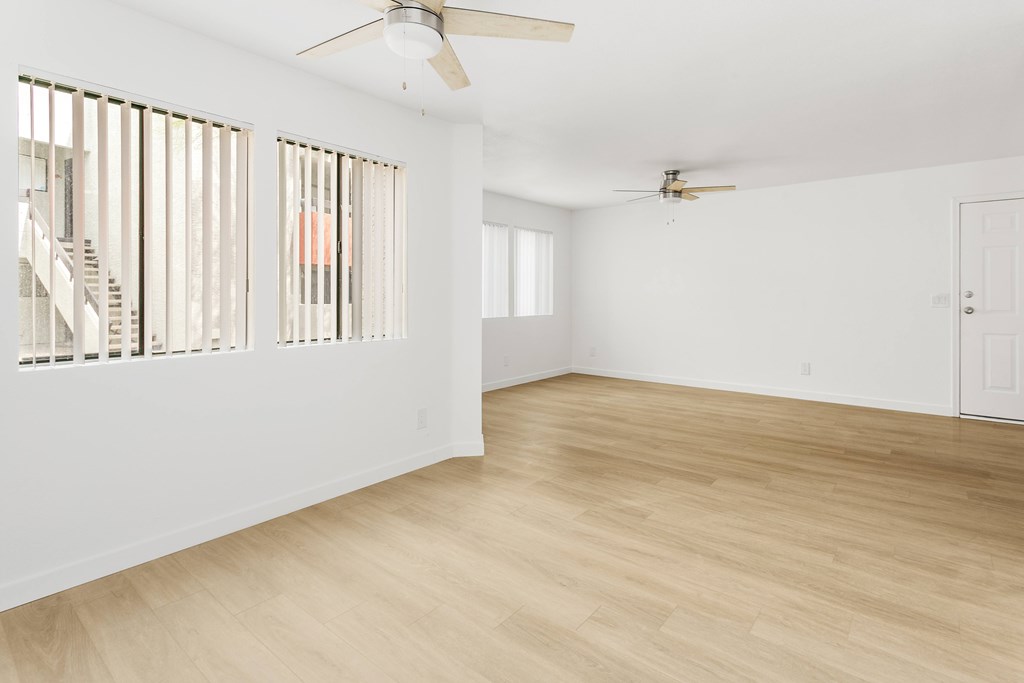 A room with wooden floors and a ceiling fan.