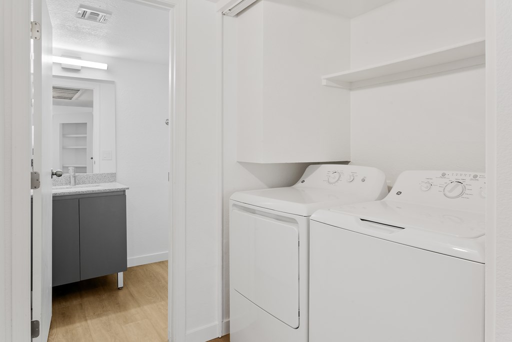 A white washing machine and dryer in a laundry room.