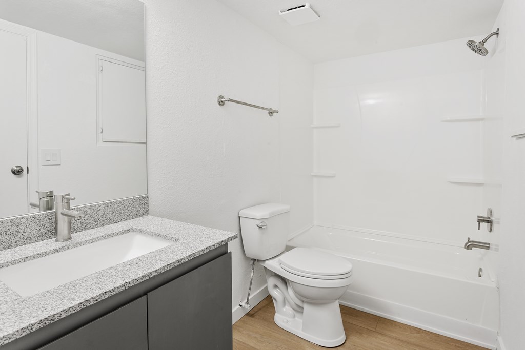 A white toilet sits next to a sink in a bathroom.