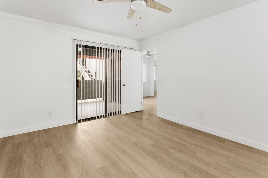 A room with a wooden floor and a ceiling fan.
