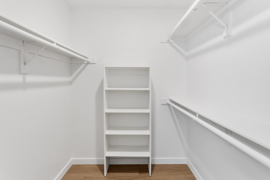A white shelving unit in a white room.