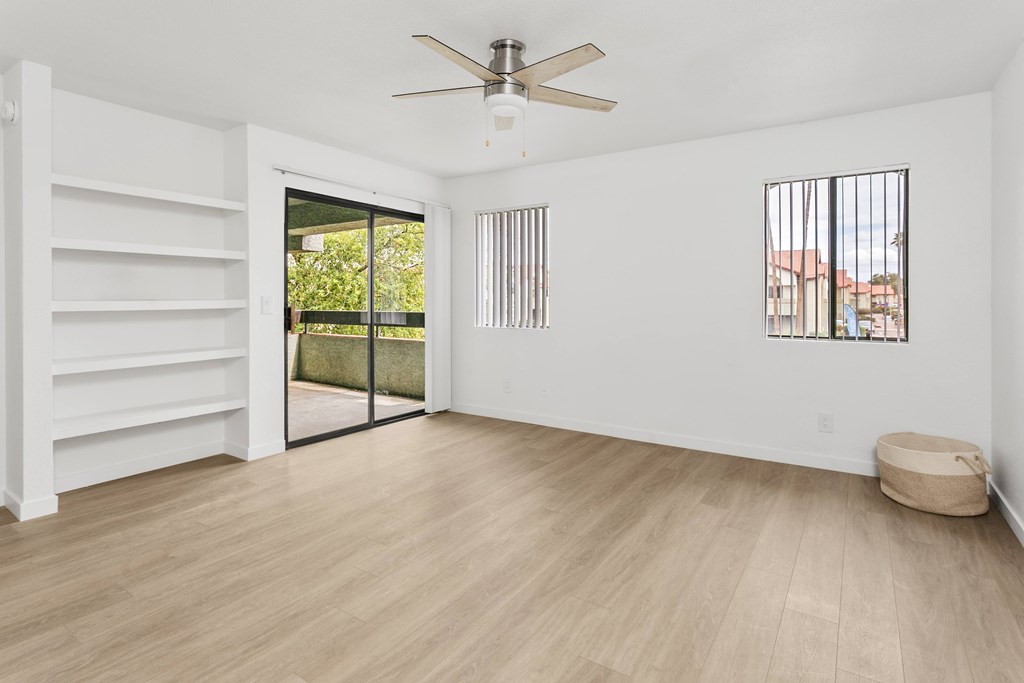 A room with a sliding glass door leading to a balcony.