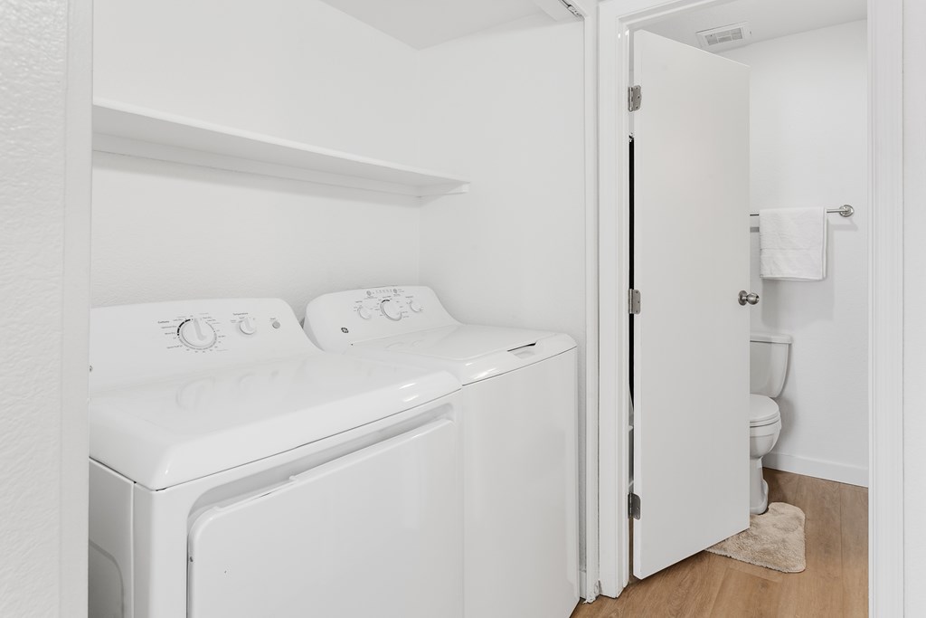 A white washing machine and dryer in a small laundry room.