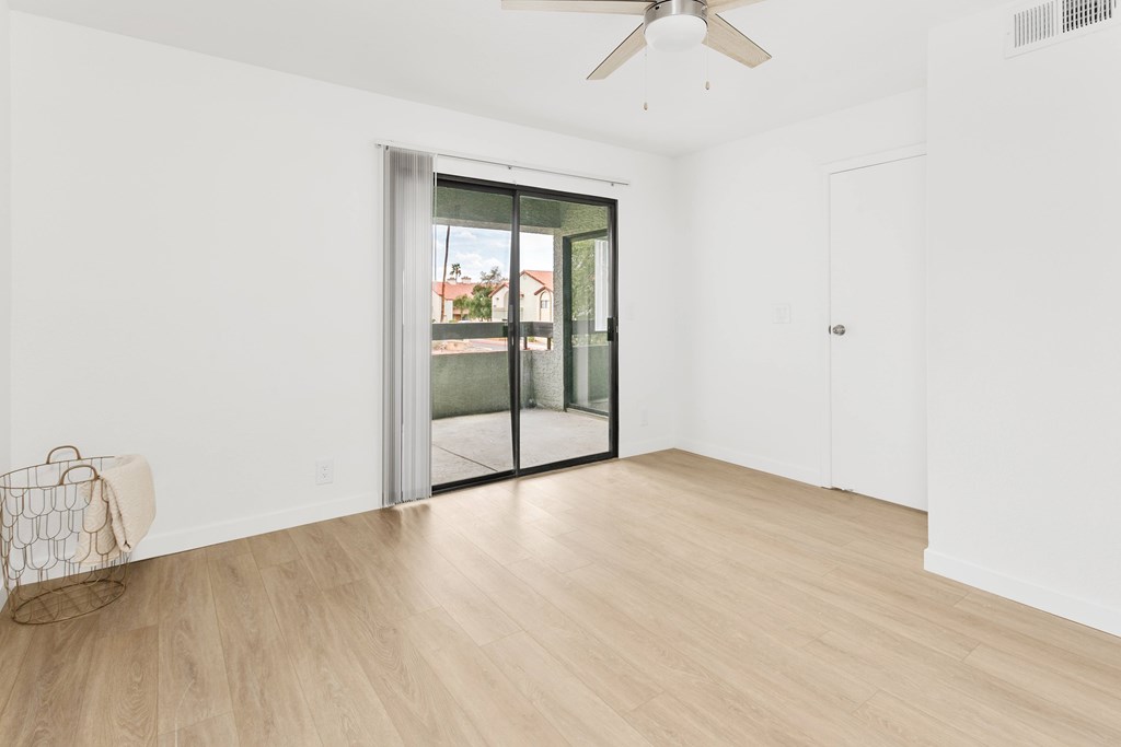 A room with a sliding glass door leading to a balcony.