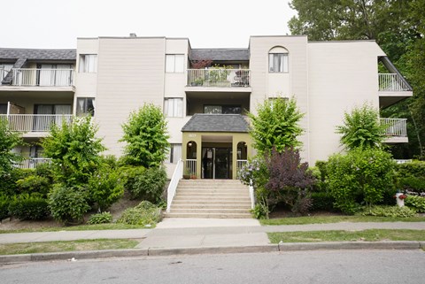 A building with a grey facade and a green lawn in front.