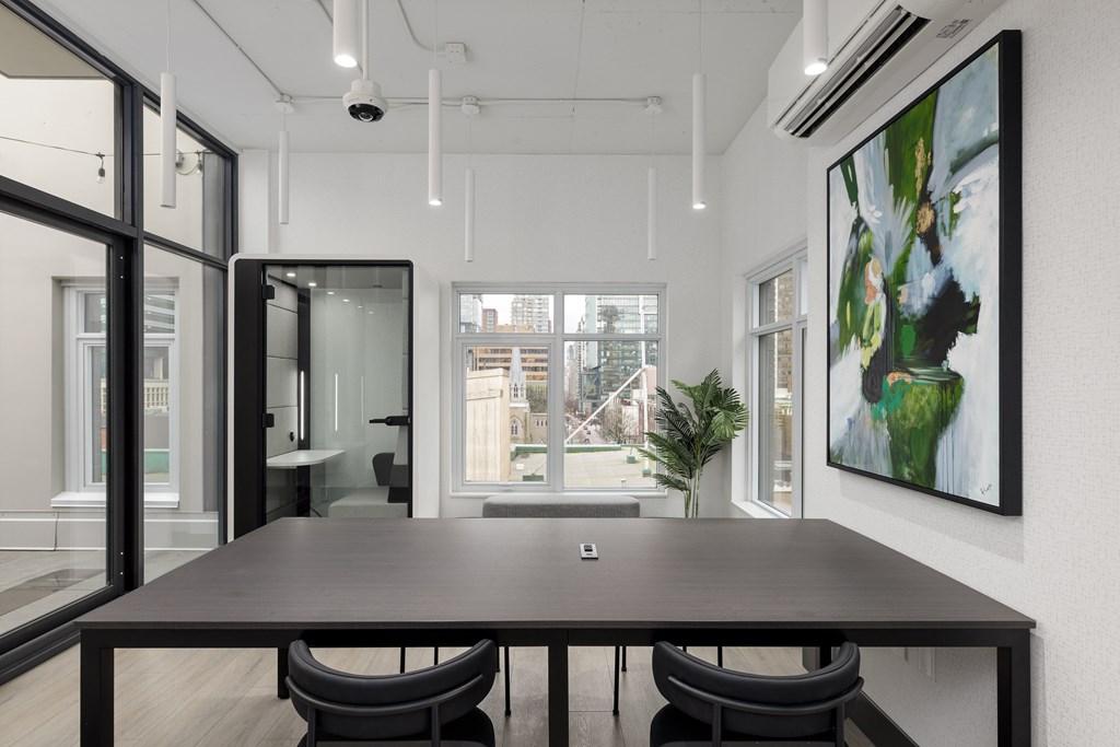 A modern conference room with a long table and chairs.