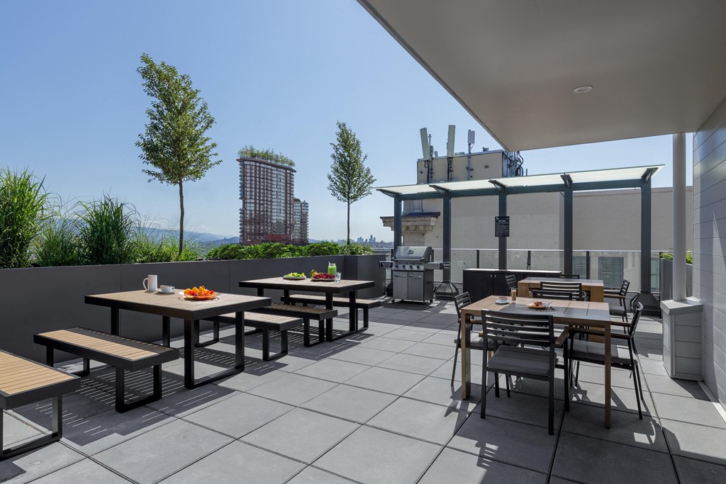 A patio with tables and chairs is set up on a rooftop.