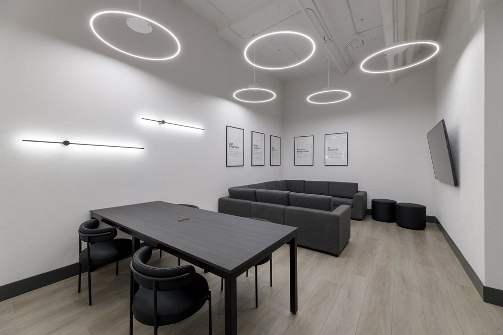 A modern conference room with a long table, chairs, and framed pictures on the wall.