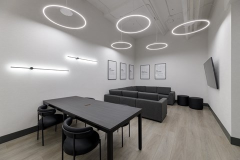 A modern conference room with a long table, chairs, and framed pictures on the wall.