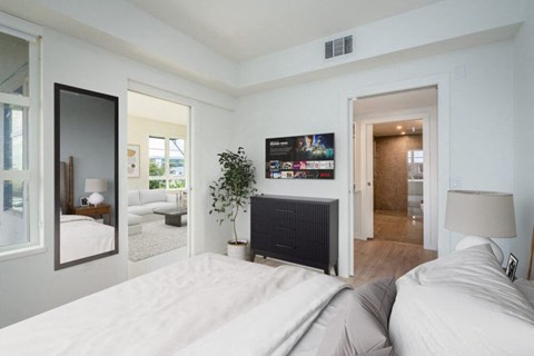 A modern bedroom with a large bed and a flat screen TV mounted above a fireplace. at SMB Hollywood Apartments, Los Angeles, 90038