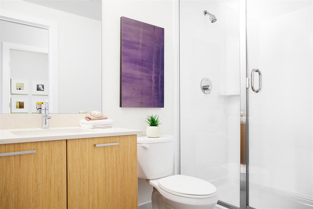 A bathroom with a toilet, sink, and a purple wall hanging.