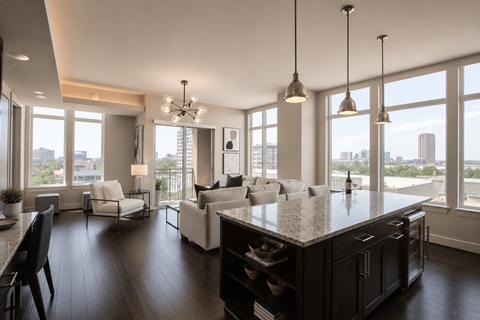A modern kitchen with a large island and a view of the city.