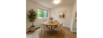 A dining room with a round table and chairs.