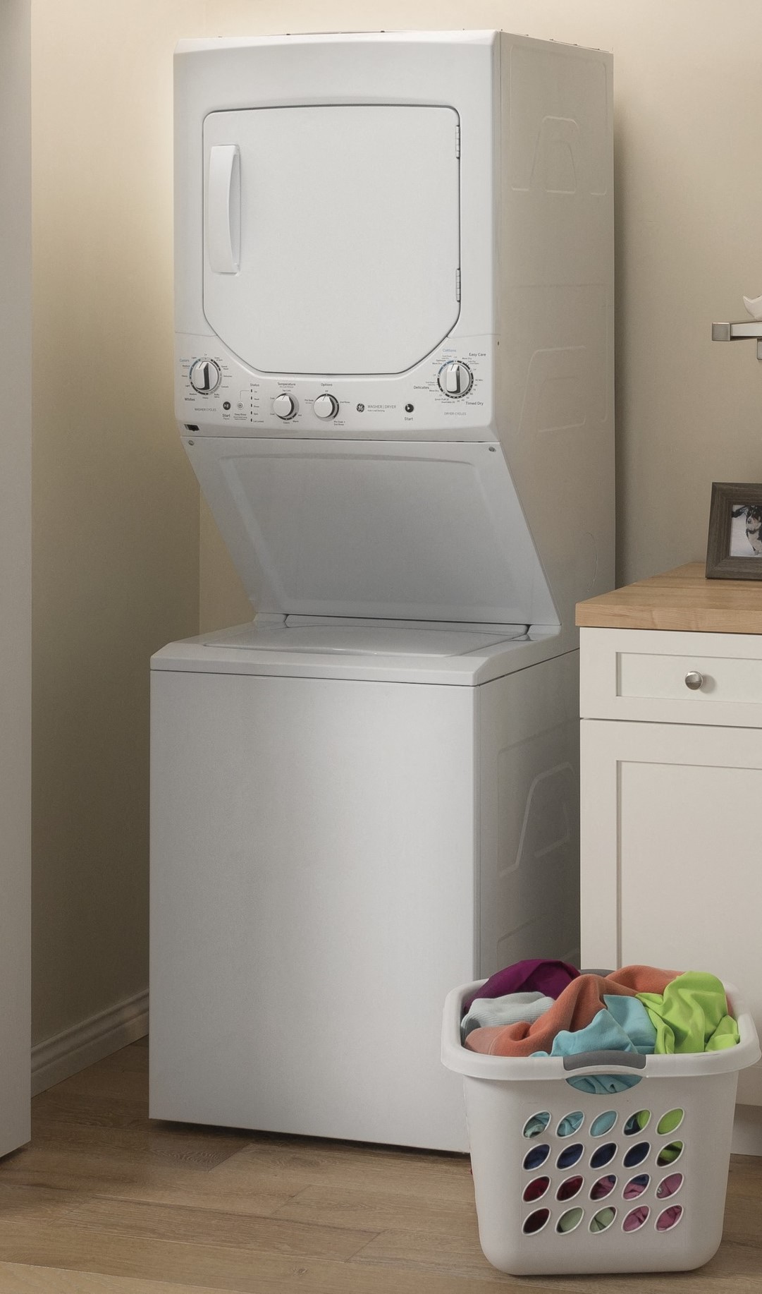a washer and dryer in a kitchen with a laundry basket