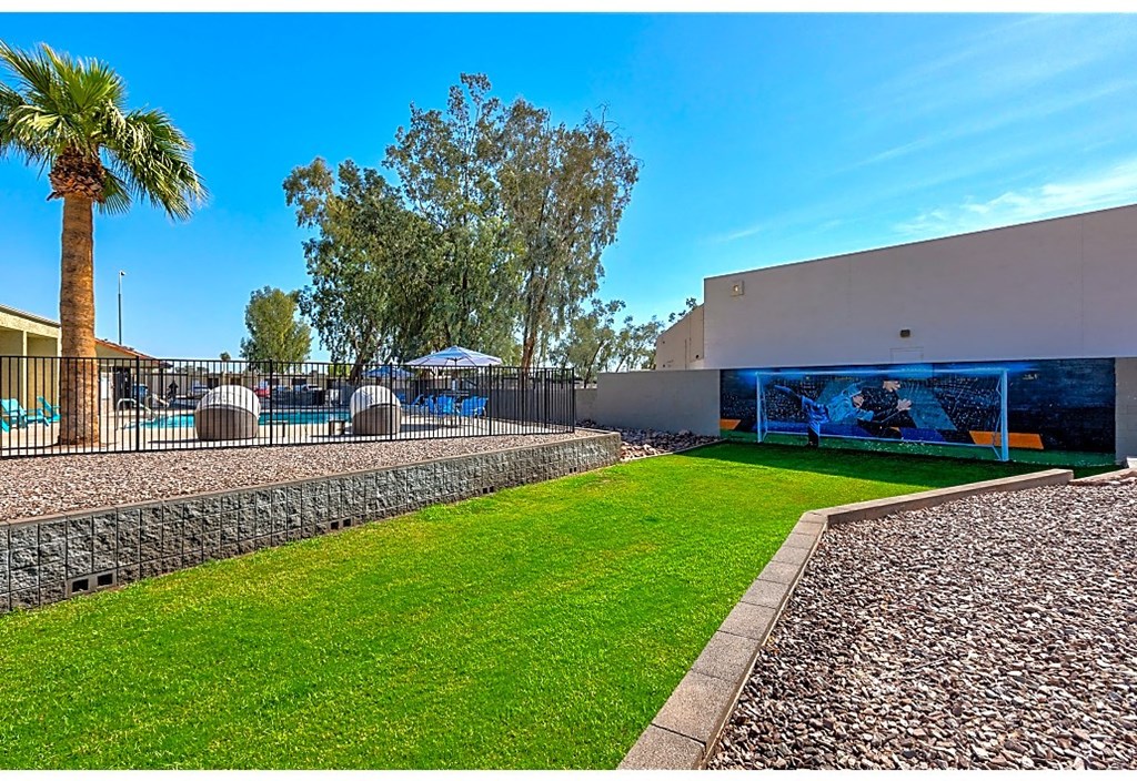 a yard with a pool and a building with a palm tree