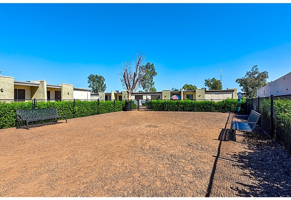 a courtyard with benches and buildings in the background