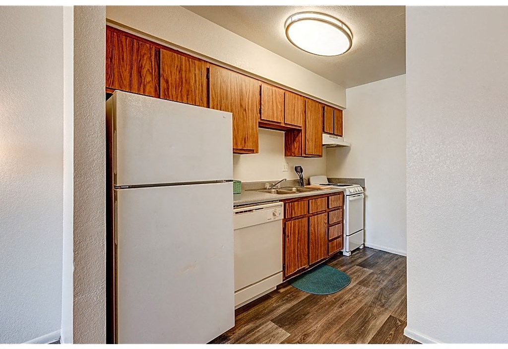 a kitchen with white appliances and wooden cabinets and a white refrigerator