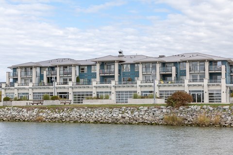 A large building with a stone wall in front of it.