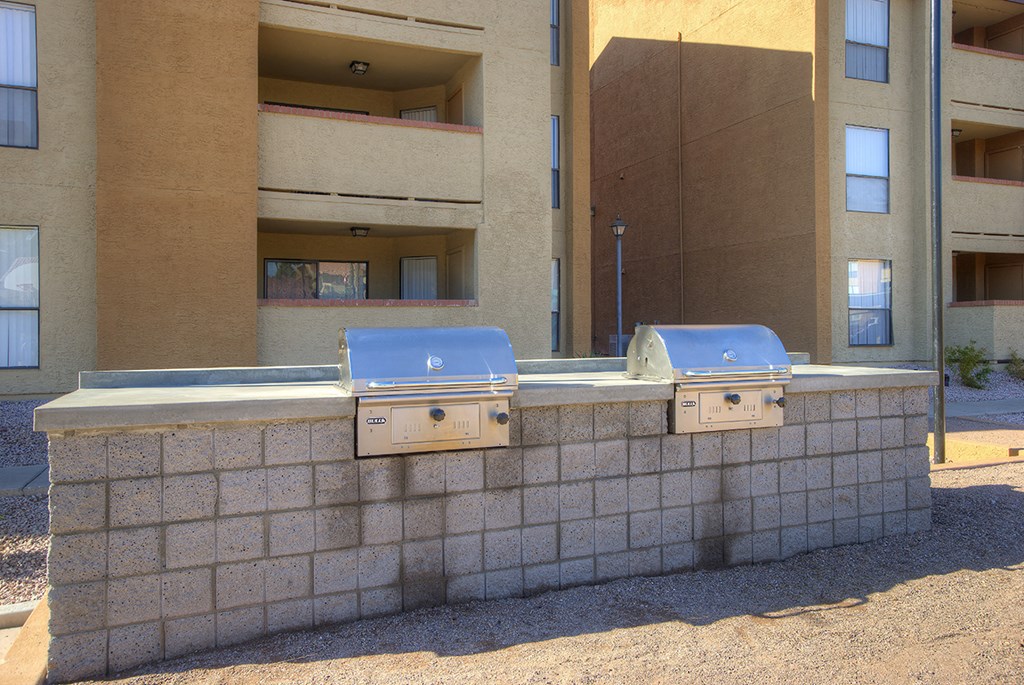three bbq pits in front of an apartment building