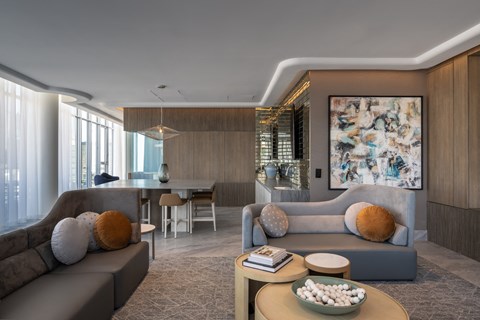 A modern living room with a grey sofa, a wooden coffee table, and a large abstract painting on the wall.