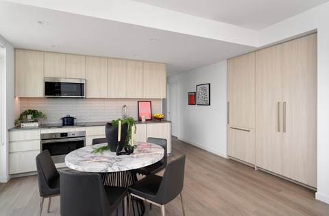 A modern kitchen with a dining table and chairs.