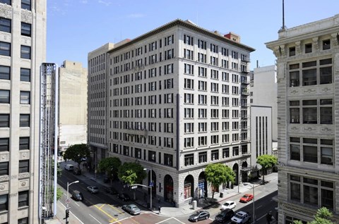 A street view of a city with a large building in the middle.
