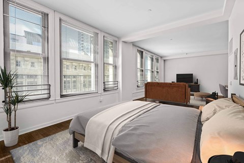 A bedroom with a large bed and a potted plant.