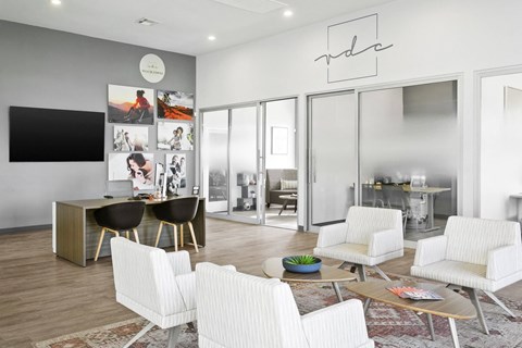 A modern living room with a white sofa set and a television.