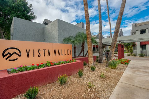 A sign that says Vista Valley in front of a building.