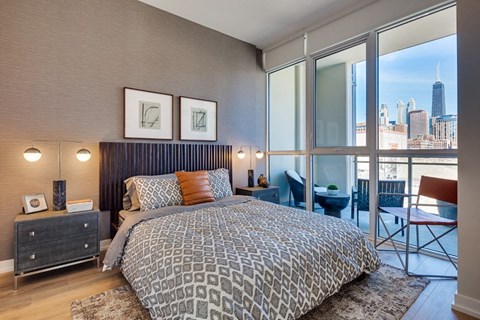 A bedroom with a large bed and a view of the city.