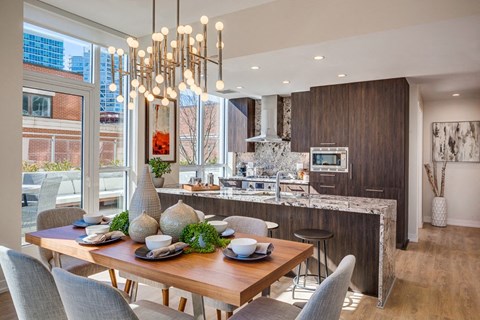 A modern dining room with a wooden table set for a meal.