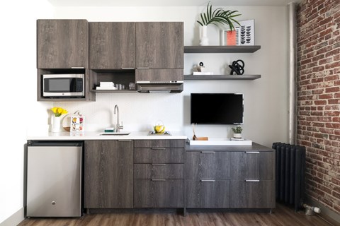 A kitchen with a microwave, sink, and refrigerator.