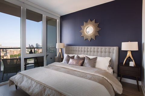 A bedroom with a large bed and a view of the city.