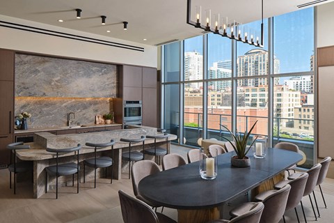 a dining room with a table and chairs and a kitchen with large windows