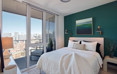 a bedroom with a bed and a green wall and a balcony