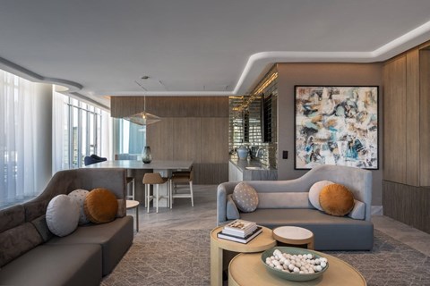 A modern living room with a grey sofa, a wooden coffee table, and a large abstract painting on the wall.