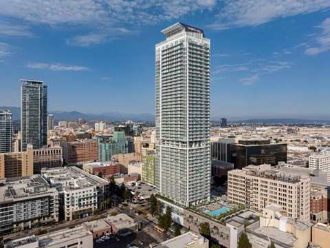 A cityscape with a tall building in the foreground and other buildings in the background.