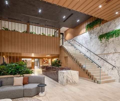 A modern living room with a staircase and a couch.