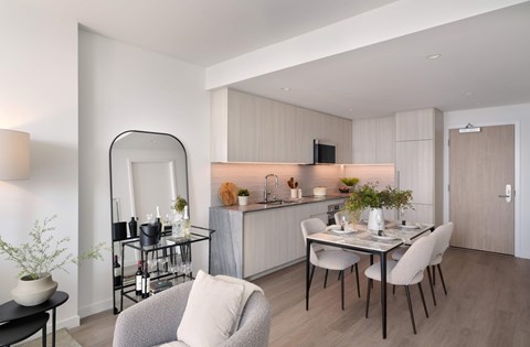 A modern dining room with a glass table and chairs.