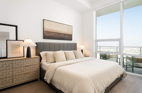 A bedroom with a large bed and a painting on the wall.