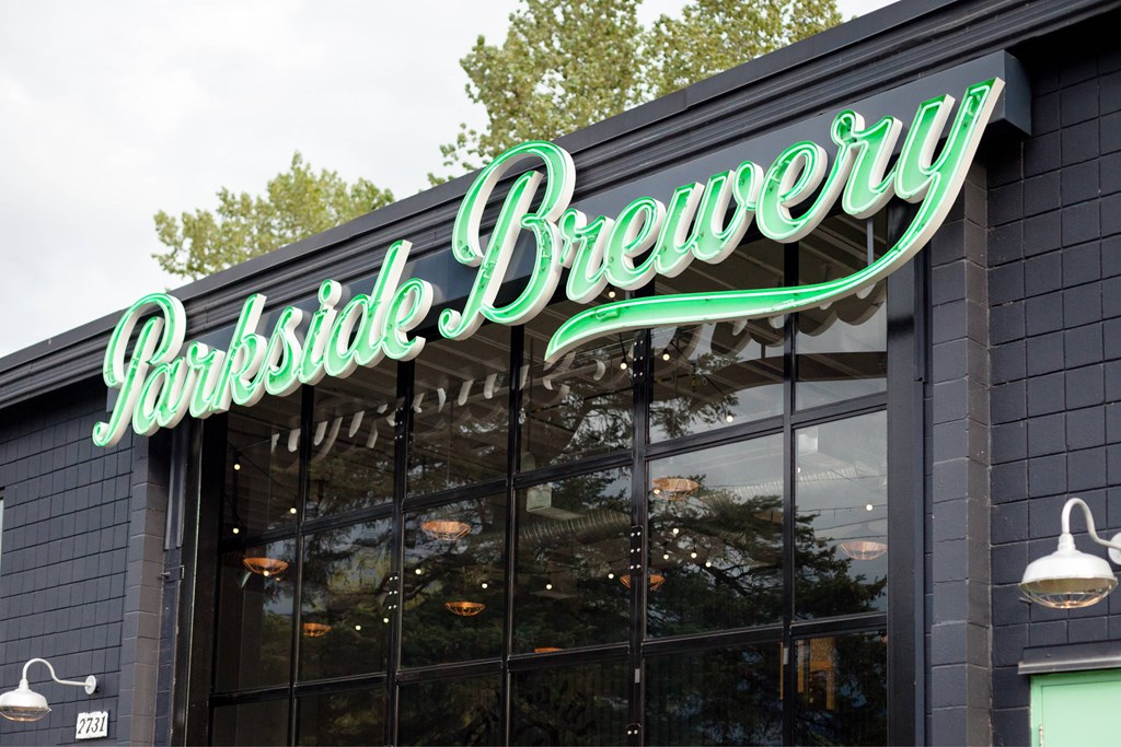 A brewery sign with a green neon light.